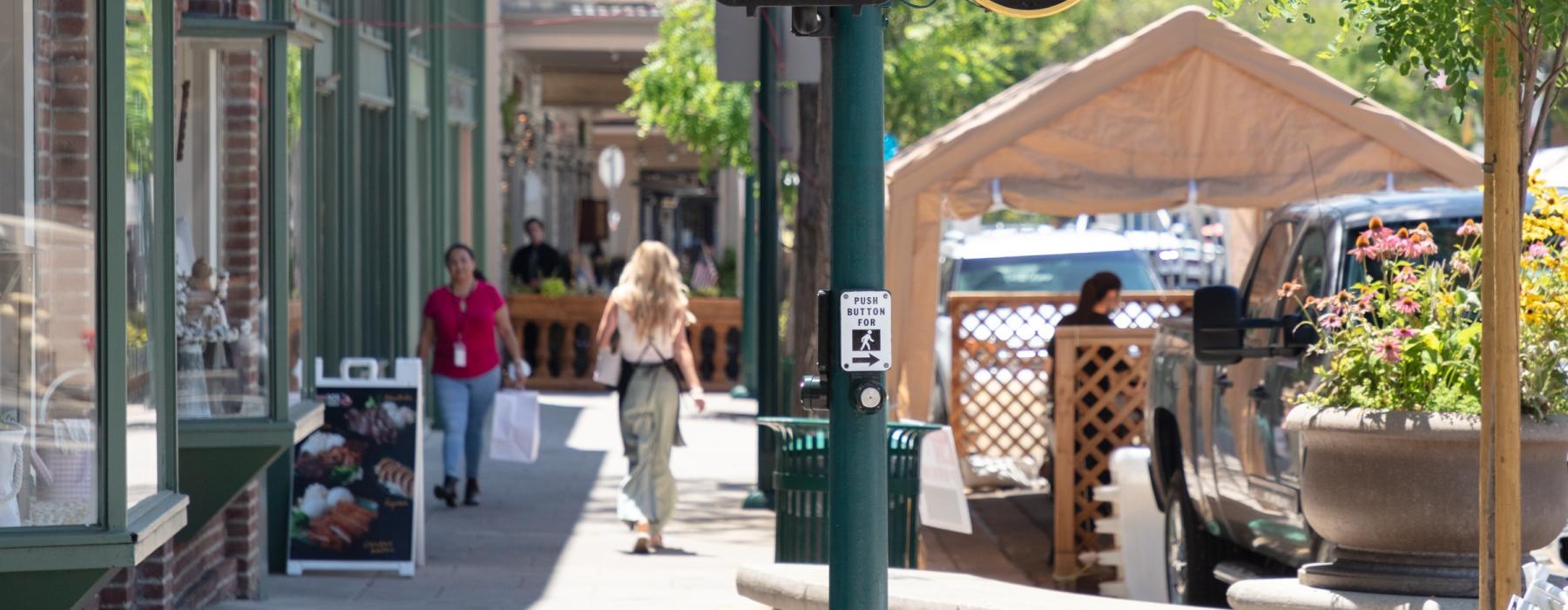 a couple of people walk down a sidewalk
